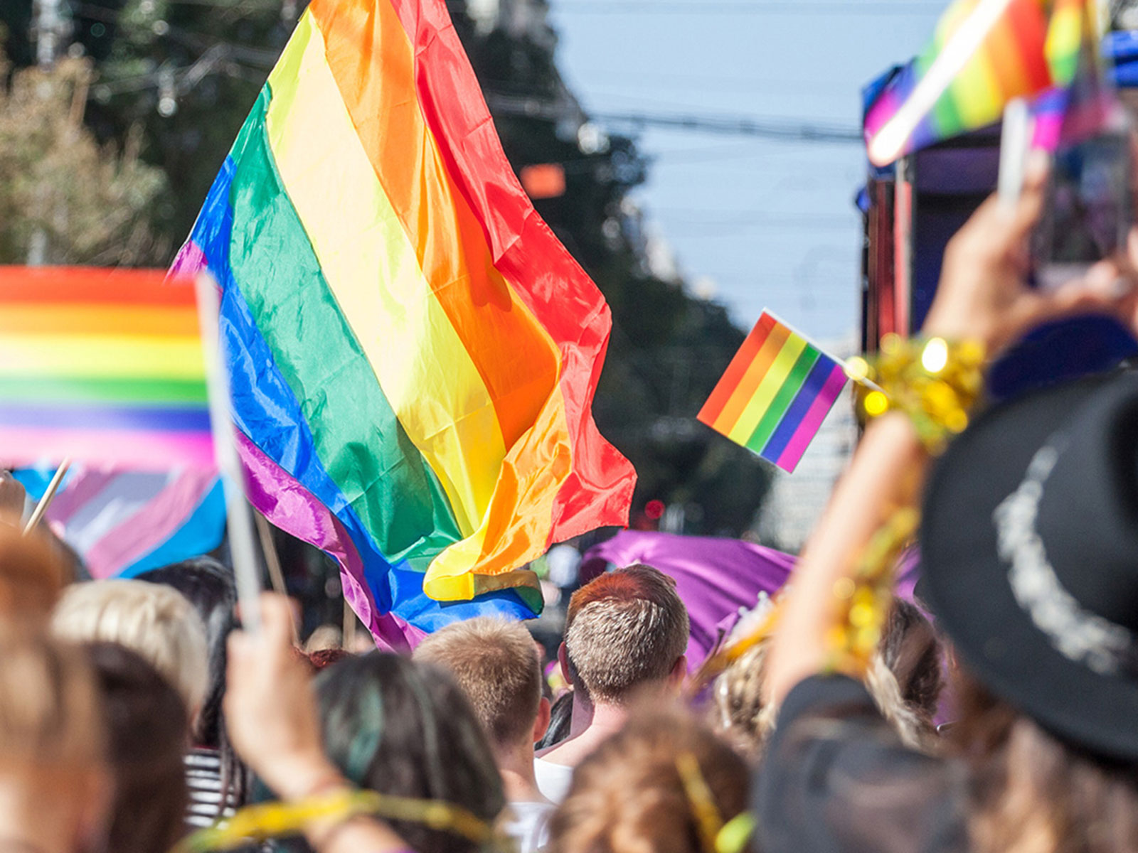 People holding rainbow pride flags | LGBTQ Equity Fund