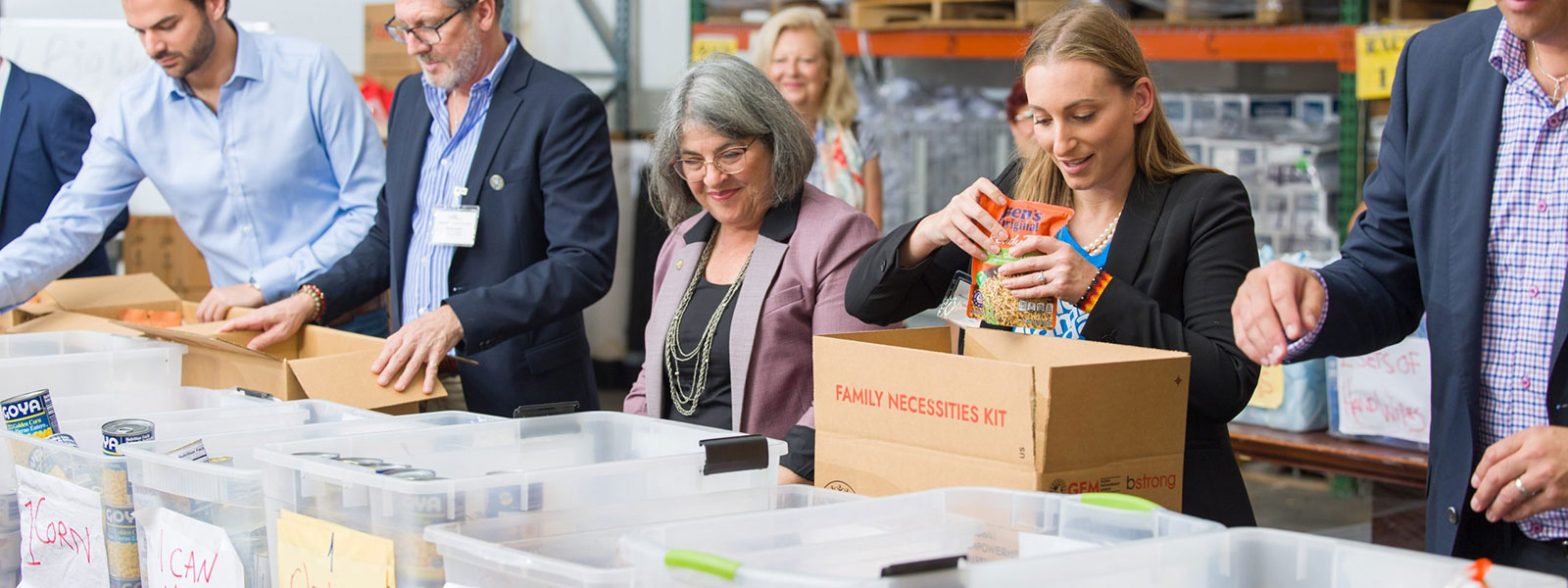 Miami-Dade County Mayor Daniella Cava and other people packing boxes of food
