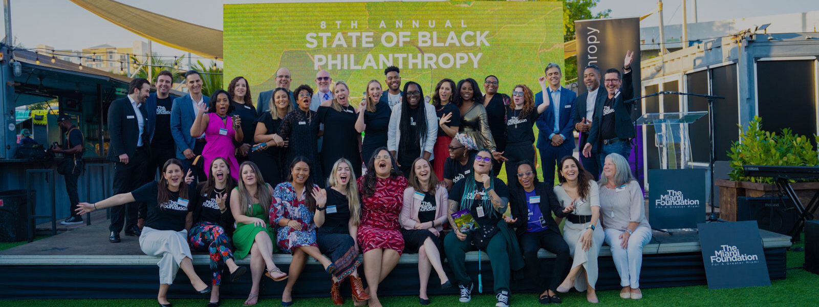 Group of people standing in front of 8th Annual State of Black Philanthropy sign