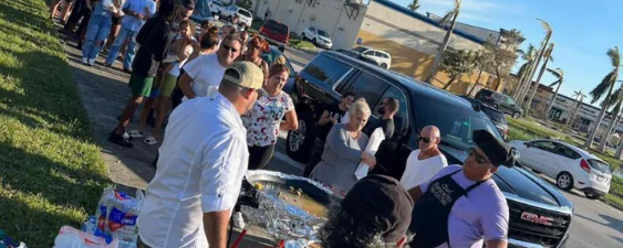 People standing along street to support those affected by hurricane